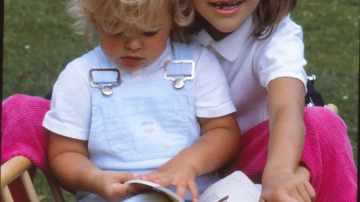 Kronprinsessan Victoria  visar sin syster prinsessan Madeleine "Första läseboken"  på Sollidens slott på Öland. Bilden togs för en intervju inför kronprinsessans skolstart 1984.