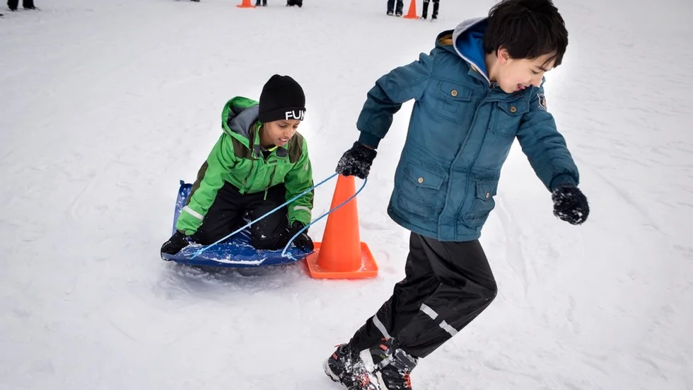 Seanodos Mussie, 9 år, försöker hålla sig kvar på madrassen när den sladdar runt konen.