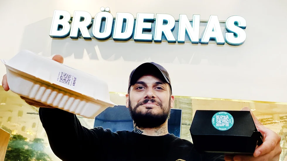 Hamburgerrestaurangen Brödernas restaurangchef i Tuna Park, Milo Sejfulova, visar upp sina förpackningar som erbjuder fyra kronor i pant vid återvinning via appen &Repeat.