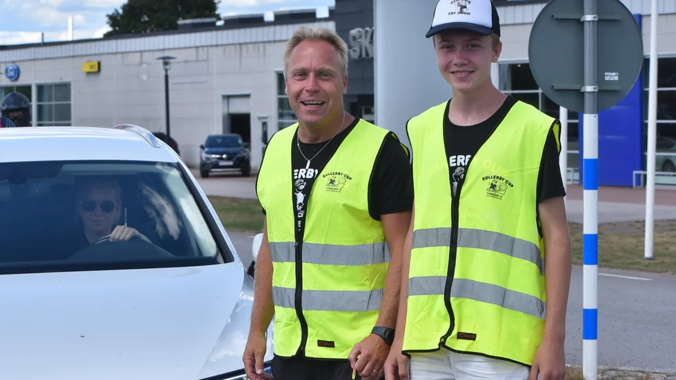  Far och son, Håkan och Olle, styr upp och dirigerar trafiken vid Bullerby Cup: "Det är roligt att prata med folk".    