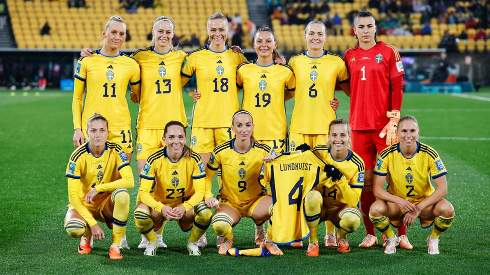 Kosovare Asllani och Nathalie Björn höll upp Hanna Lundkvist landslagströja under lagfotograferingen före VM-premiären mot Sydafrika.