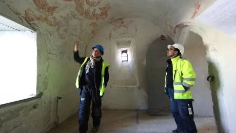 Färgsprakande sakristia. Där kalkfärgen tagits bort breder akantusmåleriet ut sig. "Ett fascinerande rum", tycker konservatorn Rebeca Kettunen och           arbetsledaren Andreas Asplund från Byggnadshyttan. Foto: Rolf Jönsson