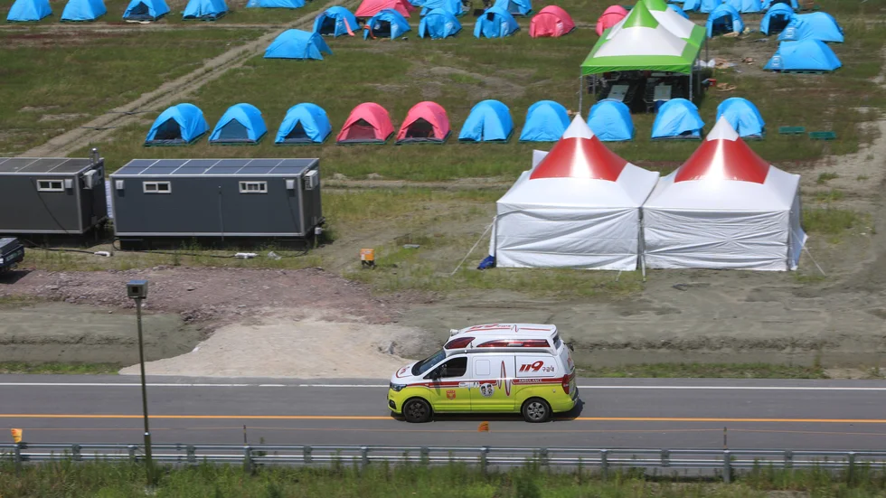 En ambulans kommer till det stora scoutlägret i Sydkorea. Många lider svårt i det extrema värmen och har behövt sjukvård.