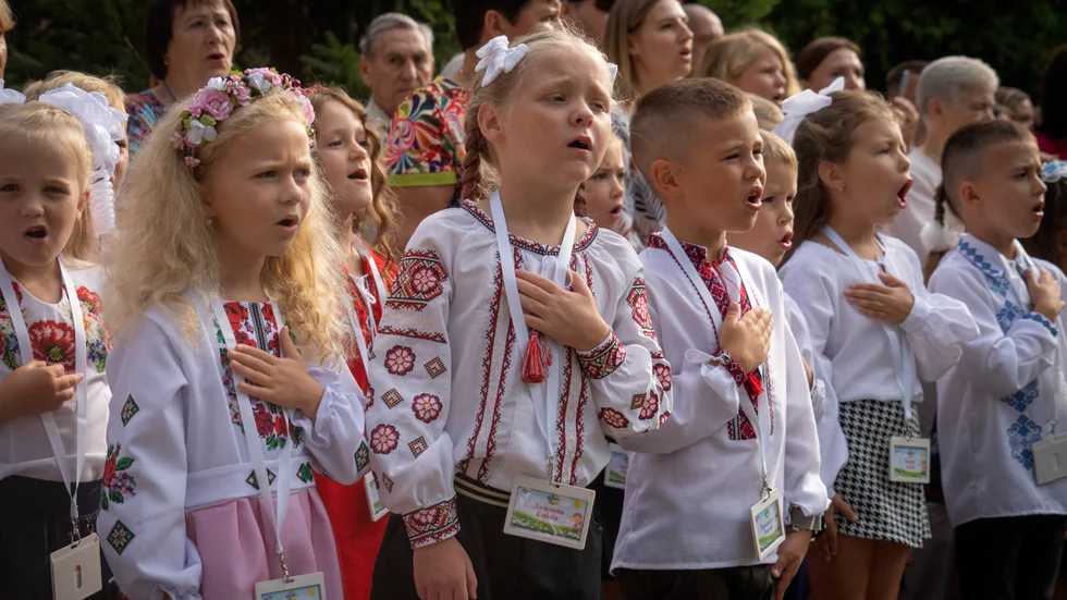 Skolbarn sjunger nationalsången på höstterminens första dag i Butja utanför Kiev.