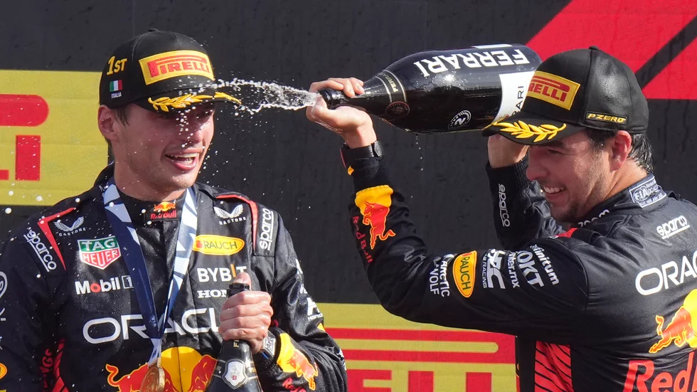 Tvåan Sergio Perez, Mexiko, låter champagnen flöda över sin historiska stallkamrat i Red Bull Max Verstappen.