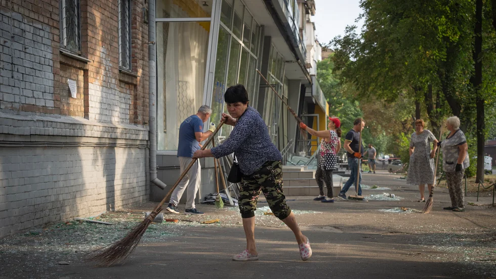 Invånare i Kiev städar bort glas och annan bråte efter en rysk drönarattack i slutet av augusti. Arkivbild.
