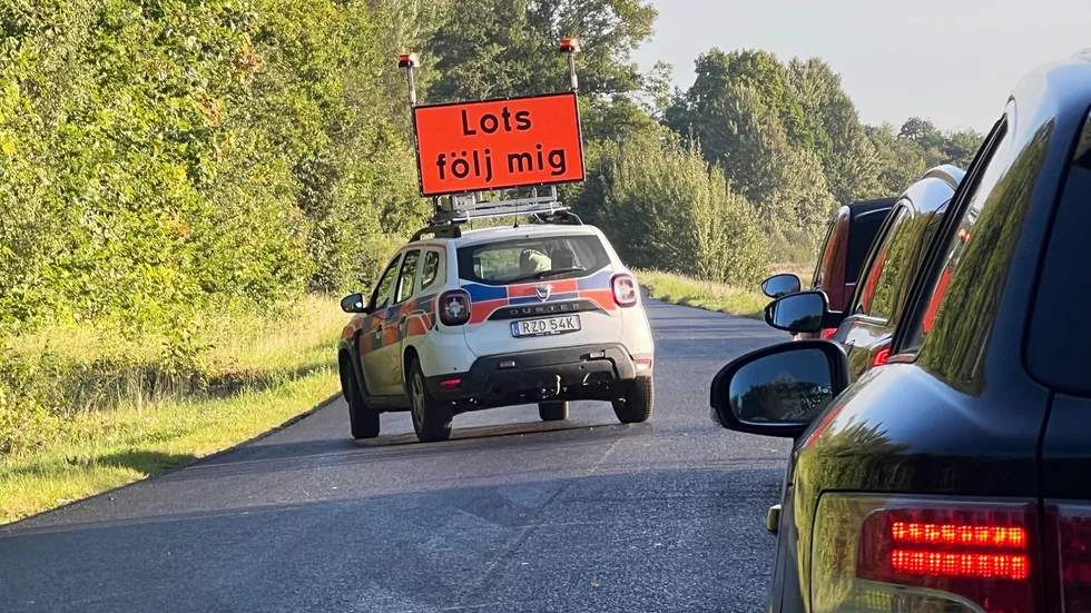 Beläggningsarbete på väg 919. En lots eskorterar trafiken på två ställen förbi beläggningsarbete och fräsning. 