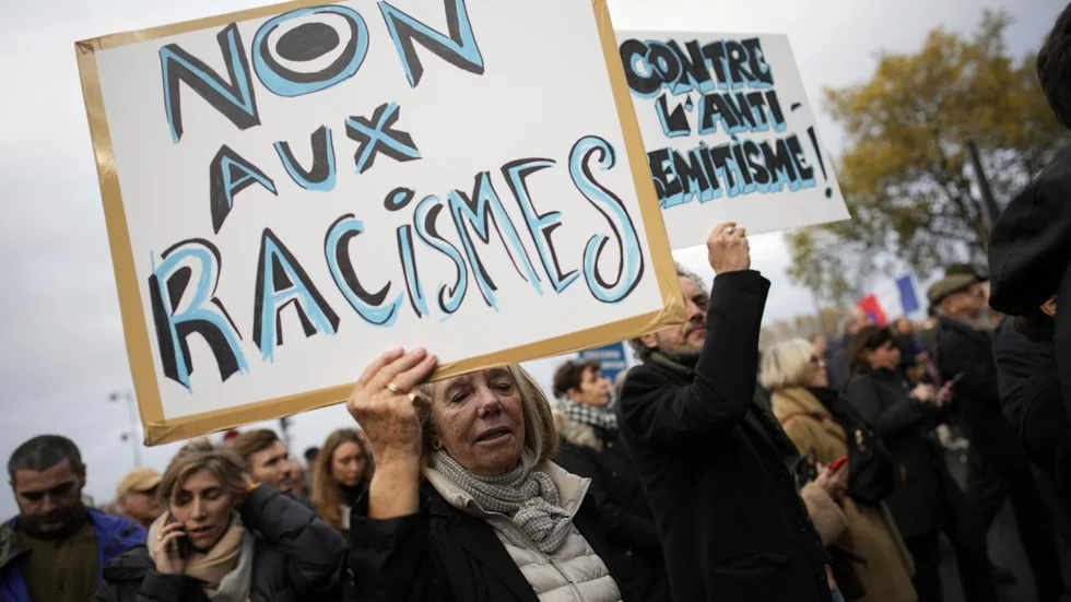 Nej till rasism, står det på kvinnans plakat under en demonstration mot antisemitism i Paris under lördagen.