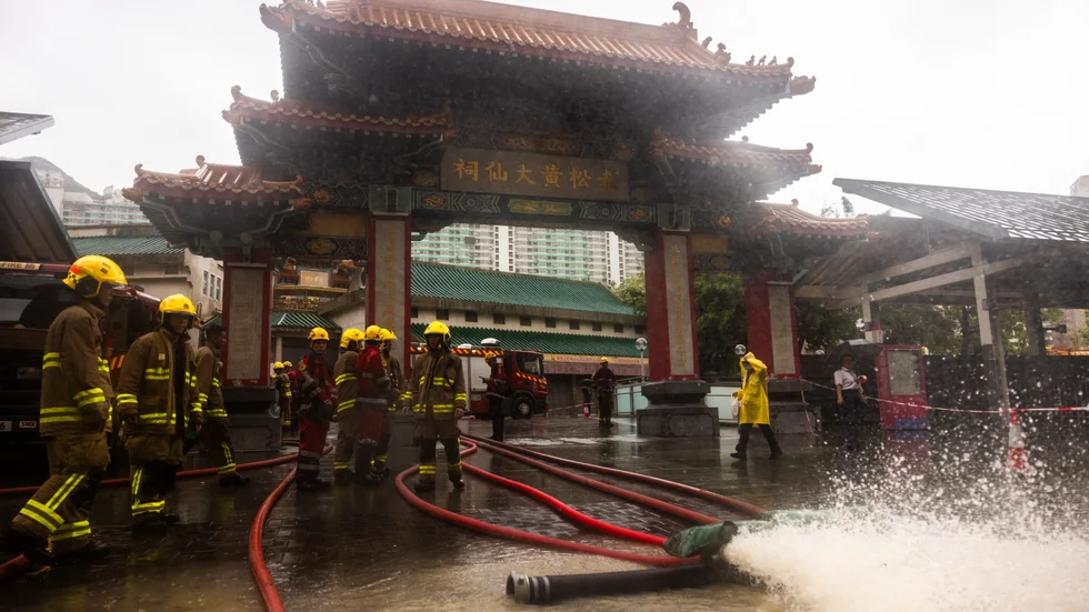 Brandmän dränerar bort regnvatten i Hongkong på fredagen.