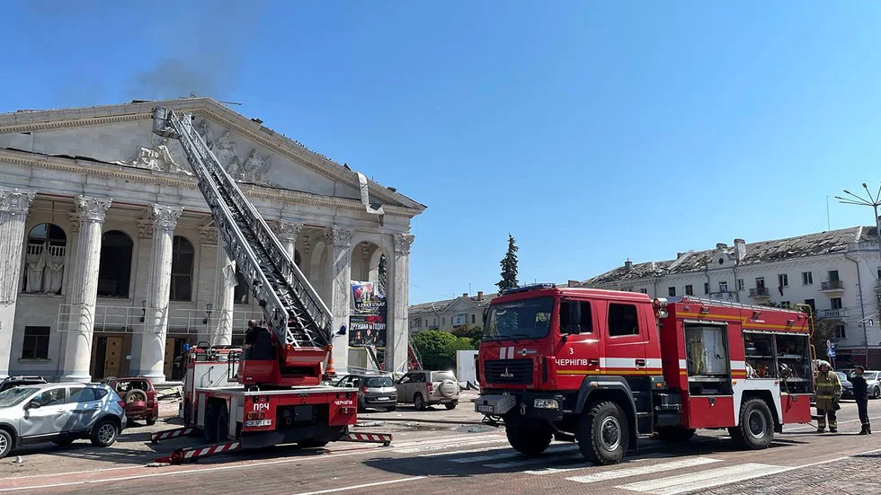 Brandmän arbetar vid Dramatiska teatern i Tjernihiv, som träffades av en rysk raket.