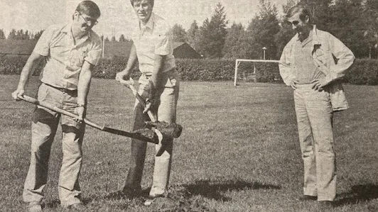 Kommunalrådet Lars Hedberg och Älvsbyhusdirektören Donald Johansson hjälps åt att ta det förta symboliska spadtaget till ishallsbygget i Älvsbyn. Intresserad åskådare är Jan Pettersson, hockeyordförande i Älvsbyn.