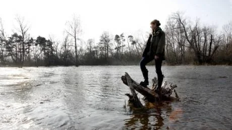 Vattenlandskap. Ängsmarkerna runt Paviken har förvandlats till en ivrigt forsande vårström. Ulla Gabrielsson blickar ut över vårfloden.  Foto: Henrik Radhe