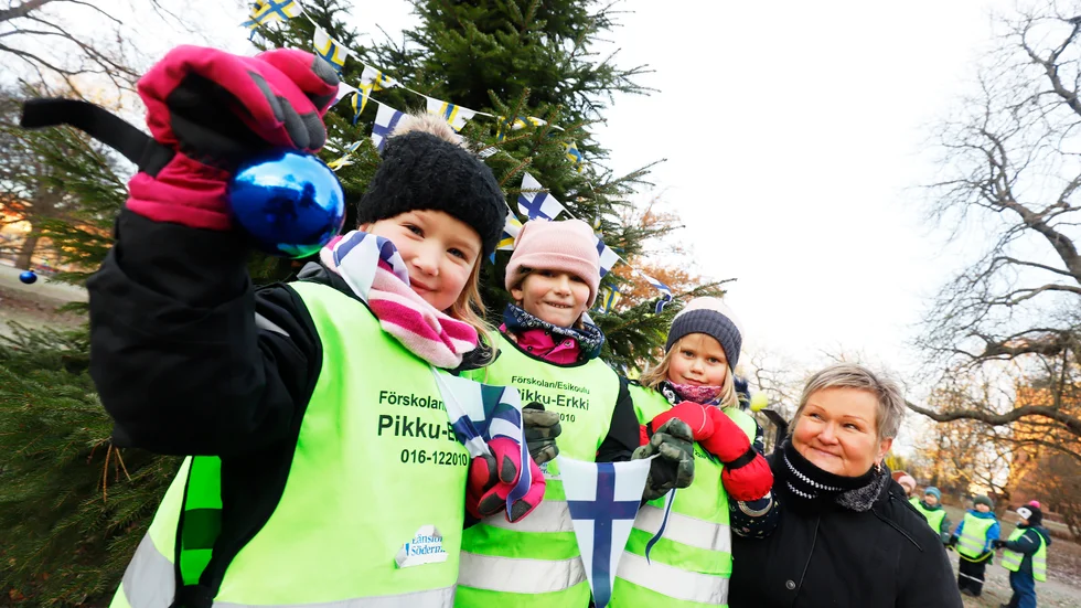 Förskolebarnen Celine Komso, Ronja Alm och Ebba Riotanheino firade Finlands självständighetsdag, tillsammans med barnskötaren Meja Palo, genom att julpynta den egenplanterade granen i Rinmansparken.