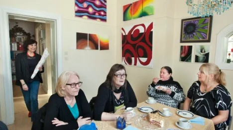 "Välkomna! Vad roligt att se er!", säger ordförande Magdalena Urgell i dörröppningen till Yvonne Bergqvist, Gunilla Sundvall, Rita Bonivart och Elisabeth Lundström vid kaffebordet.