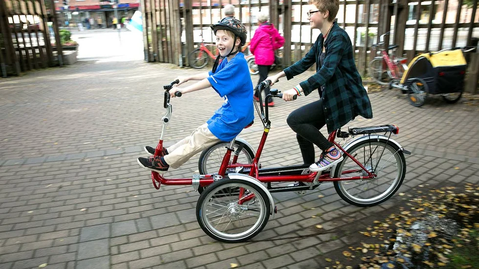 TEST. Oliver och Tovah Parnes passade på att prova Sporto­tekets senaste utlåningsprodukt. Speciellt framtagen för de som har svårt att lära sig cykla och behöver lite hjälp.