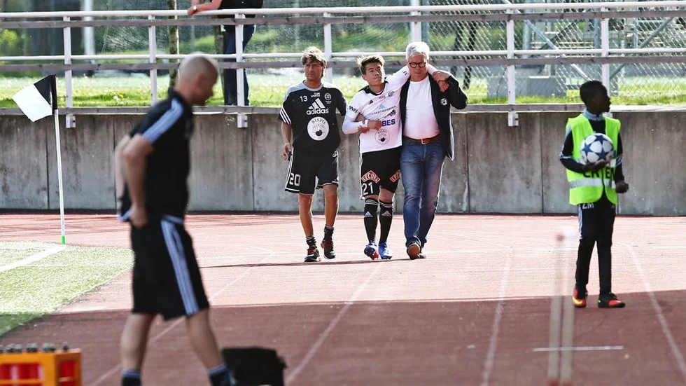SKADOR. Adam Larsson leds av planen med hjälp av lagledaren Kenny Ljungkvist och ordföranden Stellan Axelson. Larsson spelar inte mot Boo på bortaplan på söndag.