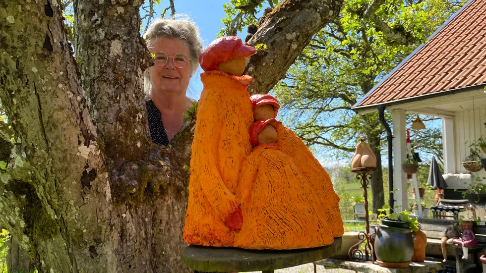Hemma hos Sissi Stahli i Björsäter är trädgården full av skulpturer i lera, som denna som fått namnet "Syskon". "Konsten är mitt bidrag till samhället. När människor kommer hit just när träden blommor och himlen är blå, så hör jag dem skratta och prata. Man blir glad."