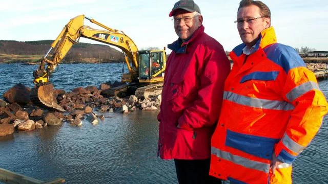 Platschefen Nick Karlsson (längst till höger) och Stellan Åberg, vd för Hästholmens hamn och magasin, beundrar hantverksskickligheten hos grävmaskinisten Sören Eriksson. Bild: LINDA H AXELSSON