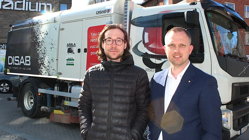 Driftingenjör Carl Eriksson och ordföranden i samhällsbyggnadsnämnden Stefan Eriksson (M) framför vakuumsugen som testats på Hamngatan.