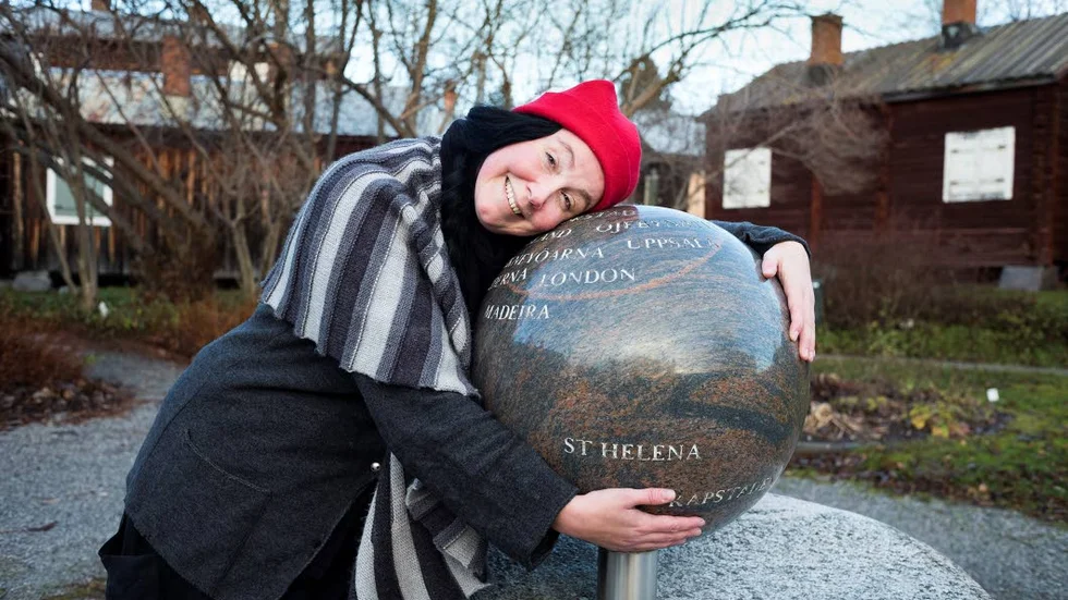 Vi måste ta hand om planeten, säger Elin Johansson och kramar  minnesmärket över Piteås välkända jordenruntresenär Daniel Solander.