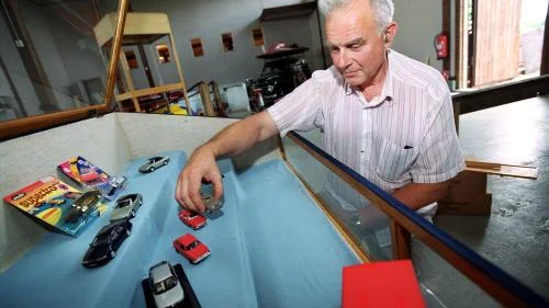 Hans Werneus har en bråd stund så här före museets öppnande. Här placerar han omsorgsfullt ut bilarna i Saab-montern. Hans äger cirka 9 000 miniatyrbilar och han kan inte sluta samla på sig fler.