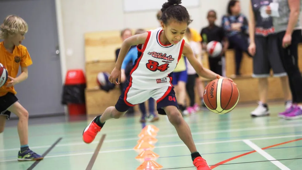 Fullt fokus. Byt hand vid varje kon, dribbla och täck bollen. Barnen i basketskolan lär sig nya saker hela tiden.