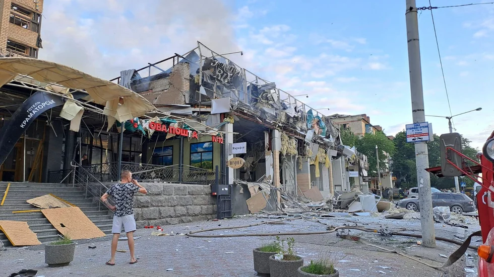 En man står på gatan framför restaurangen i Kramatorsk som träffades i en rysk robotattack.