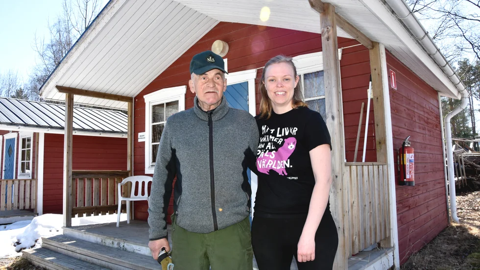 Bengt Ek och Josefin Skott Thudin framför den stuga där Bengt numera bor. "Det är hur mysigt som helst här" säger han.