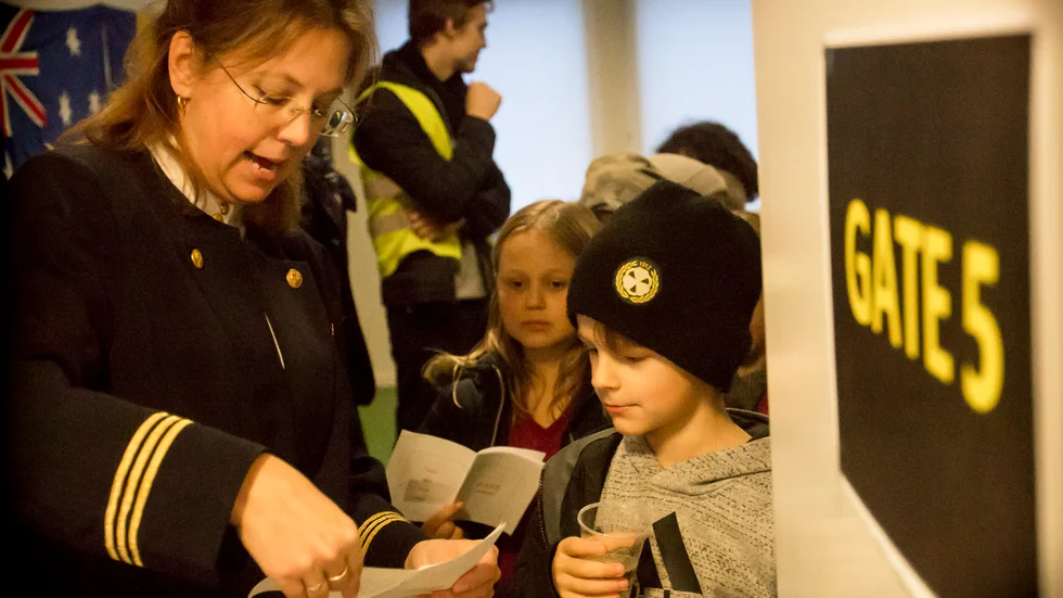 Allt är i sin ordning. Flygvärdinnan Frida Nyqvist välkomnar elever från Ringduvan genom gaten.