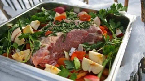 Fläskkarré med ben som ugnssteks långsamt med frukt, grönsaker och färska örter sköter sig själv i ugnen.