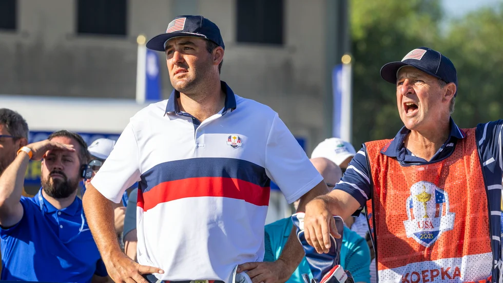 Världsettan Scottie Scheffler ser tillsammans med Brooks Koepkas caddie Ricky Elliott på när Koepka skickar ut bollen bland publiken.