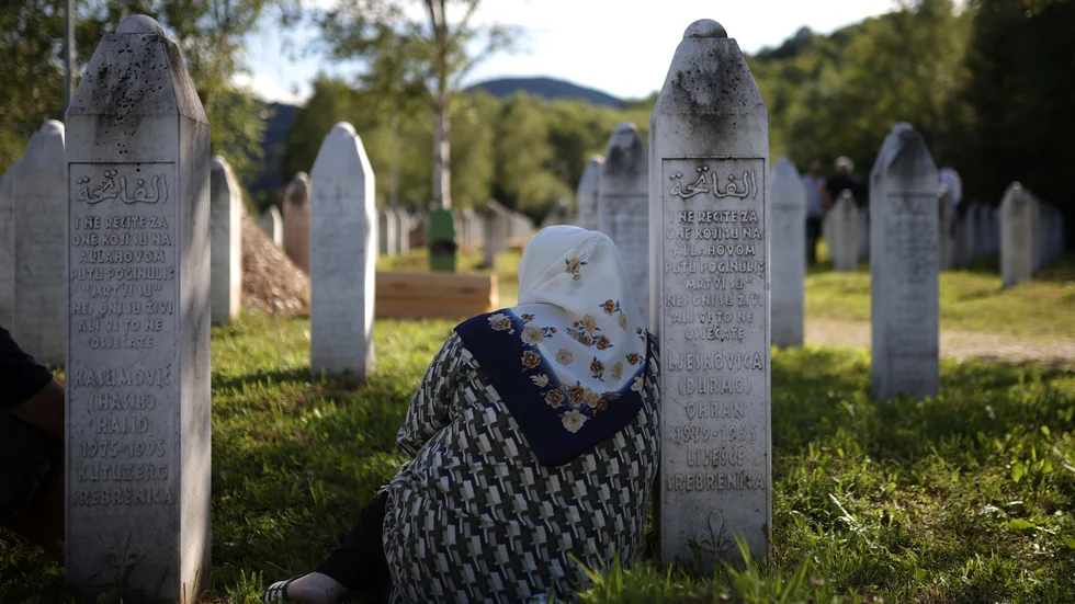 Sörjande vid en grav i minneslunden i Potocari i Bosnien där många offer för folkmord under Balkankriget ligger begravda. Arkivbild.