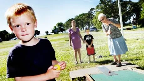 Golfstjärnor. Albin Ekström, mormor Alice Klintberg, Helena Ekström och Gustav Ekström spelar minigolf i sommarvärmen.