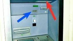 Pilarna visar vilka områden som bankomatkunden bör vara uppmärksam på. Vid korthålet (blåa pilen) placeras den s k skimmern som läser av ditt bankkort. Pin-koden kommer de åt genom att placera en minikamera (röda pilen) som fotograferar när du slår in din kod. Överföringen sker trådlöst.
FOTOMONTAGE: JANNE FORSBY