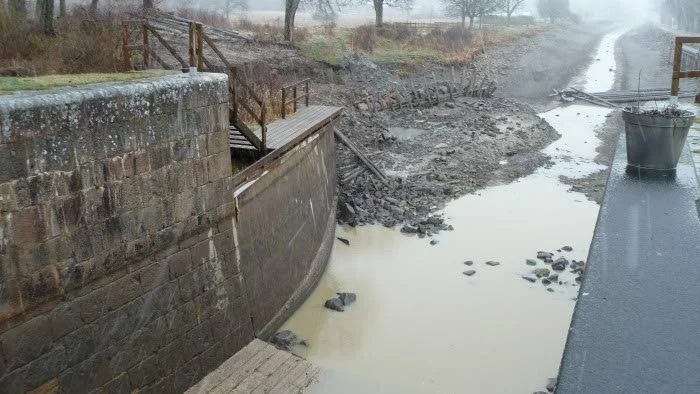 Här ses jordskredet i Göta kanal vid slussen Duvkullen Nedre, där en grävmaskinist bara var sekunder från att dras med i skredet.