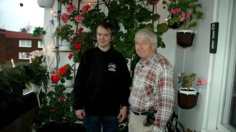 På Kjell Andersens och Kaj Andersens balkong lyser julbelysningen upp de blommande pelargonerna som ännu klarat sig undan frosten. Foto: Matilda Wiman