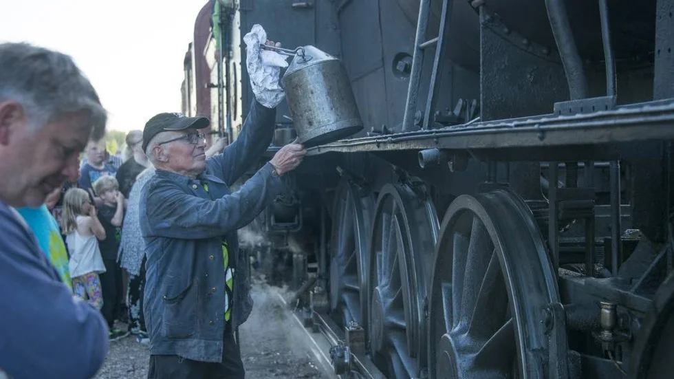 Smörjning. Lars Lindström, trafikchef Arvidsjaurs järnvägsförening, oljar in loket vid stoppet i Slagnäs.
