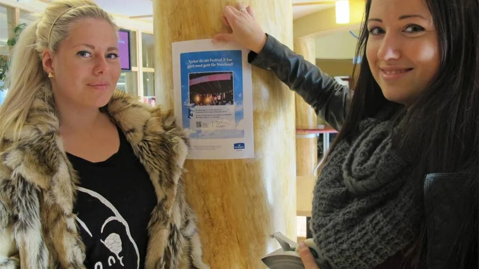 Moa Ahlgren Brynolfsson (till vänster) och Jennifer Markström är i full färd med att sätta upp flyers med uppmaningar till alla att rösta på Festival X, ett av fem eldsjälsprojekt  i Norrbotten som nominerats tilll Norrmejerier-stipendiet 2013.