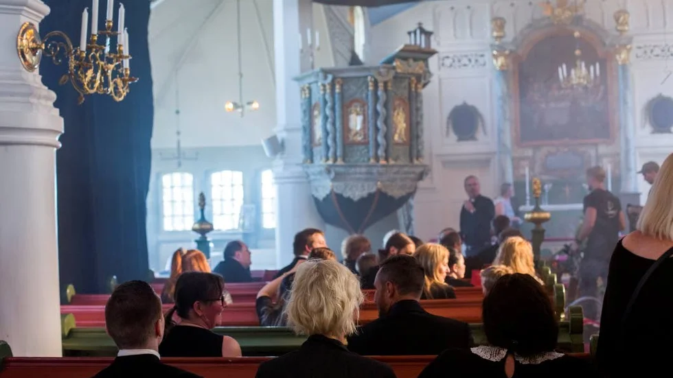 Statisterna har blivit utplacerade i bänkraderna. Det är en hel del väntan i filmvärlden - snart har de varit på set i fyra timmar.