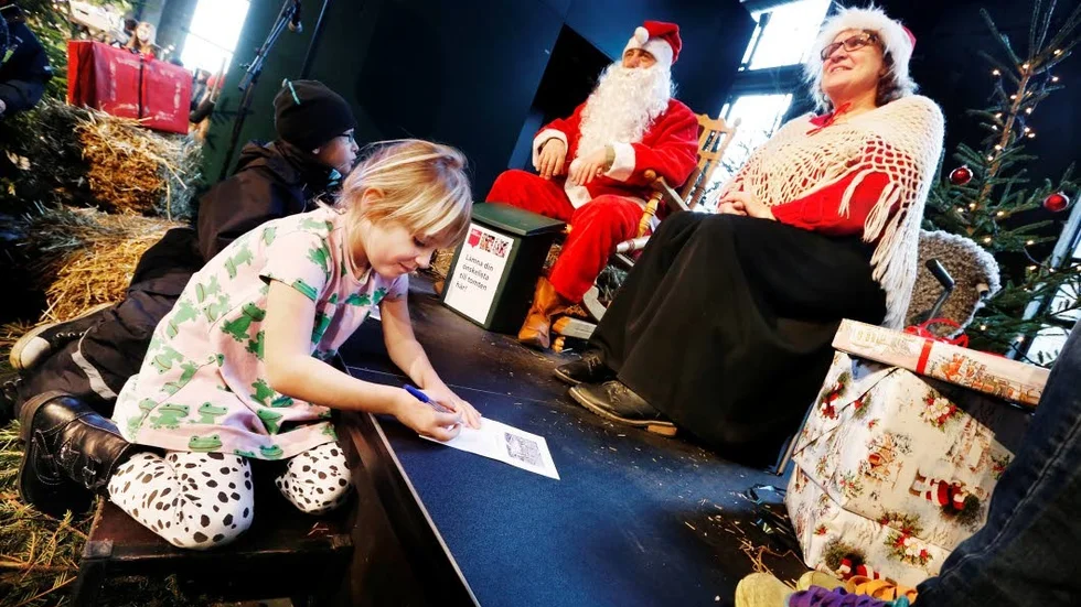 Clara, fyra år ritar en önskelista som ska lämnas till jultomten och tomtemor som finns på plats livs levande.