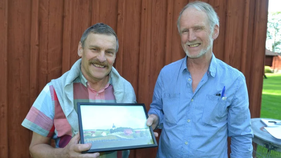 Årets Regnabo. Örjan Andersson, till vänster, har utsetts till Årets Regnabo och här har Sören Sköld, vice ordförande i Regna Hembygdsförening. just överlämnat en tavla som minne av utmärkelsen.
