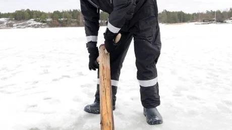 Roland Pettersson från S:t Anna hembygdsförening demonstrerar tjugan. Ett specialredskap som används för att skjuta och manövrera råträt till nästa vak.