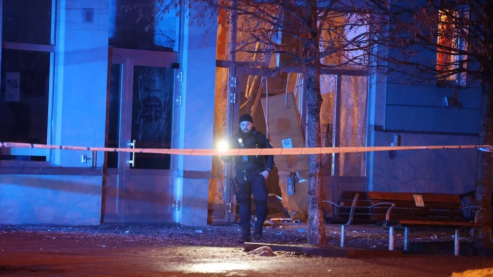 Porten till ett flerbostadshus i Uppsala sprängdes vid bombattentatet. Nu har en 18-åring häktats. 