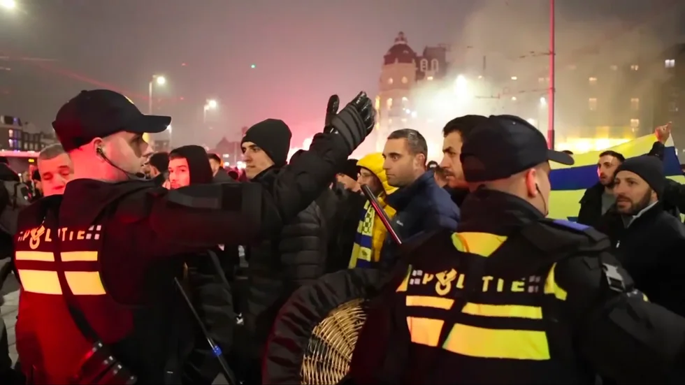 Polis eskorterar Maccabi Tel Aviv-fans till en tunnelbanestation i samband med tumultet på torsdagen. Stillbild från ett videoklipp.