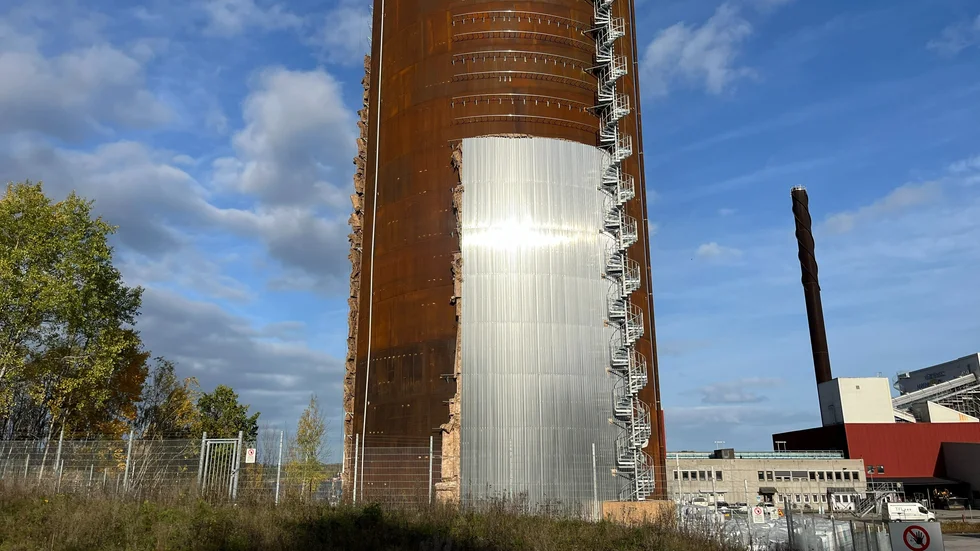 Ackumulatortanken vid Västerviks kraftvärmeverk får nya kläder. Bakom aluminiumplåtarna lägger man tjock isolering.