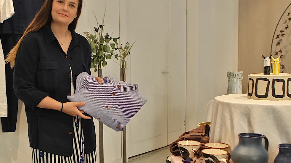 Butikens Emma Jernberg visar fram ett av Olga Ridnes plagg. 