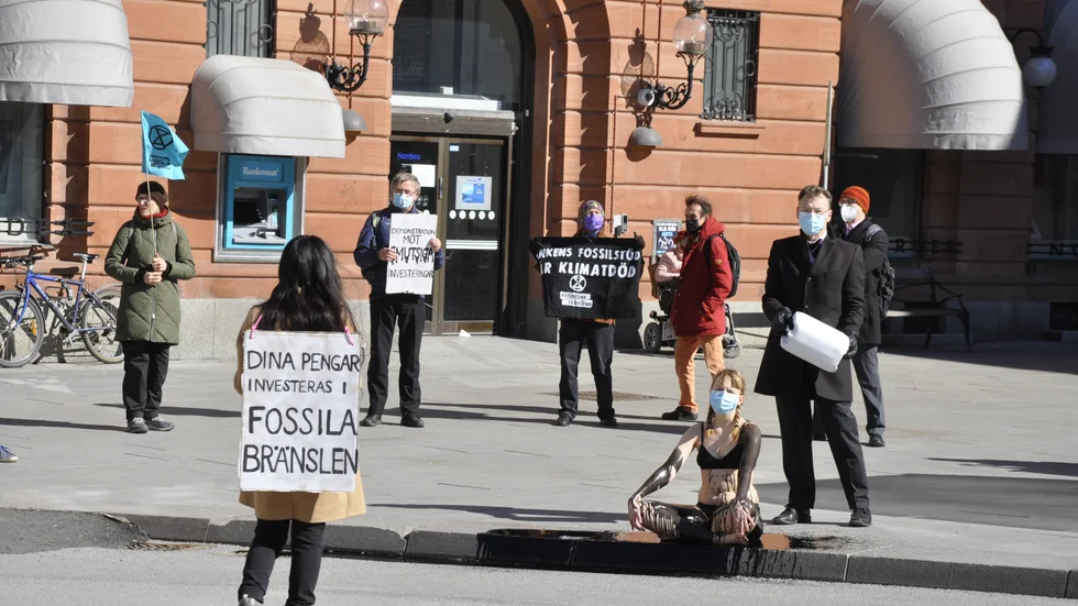 "Vi har hällt fejkolja över en frivillig för att symbolisera att bankerna inte bryr sig om oss", säger Henrik Johansson från Extinction Rebellion Uppsala.