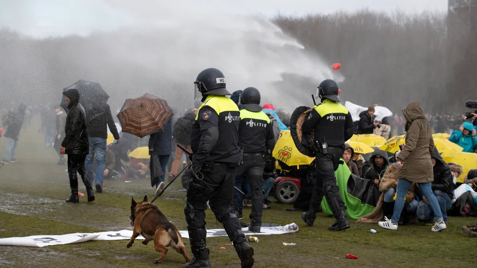 Vattenkanoner och hundar användes av polisen för att bryta upp en protest mot coronarestriktionerna i Nederländerna.