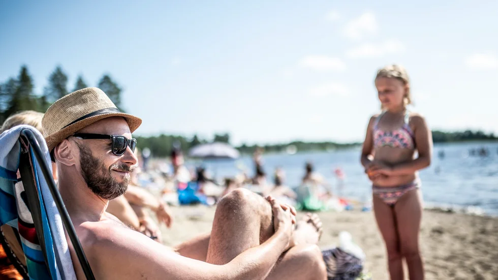 Henrik Östlund med familj njuter i värmen på stranden i Sjöbosand.