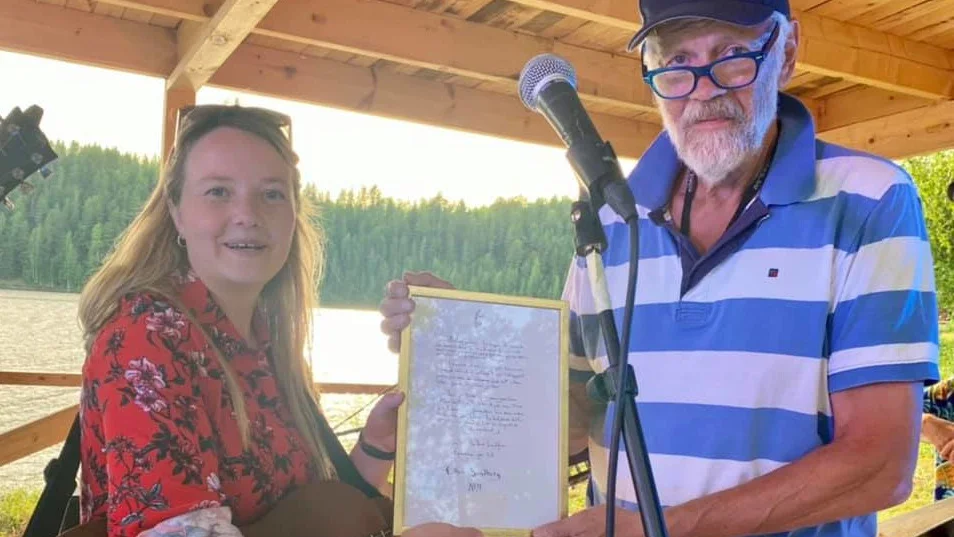 Ronny Eriksson delar ut Stipendiet i Arthur Landfors anda till Ellen Sundberg, som även uppträdde på visfestivalen Sommarljus.